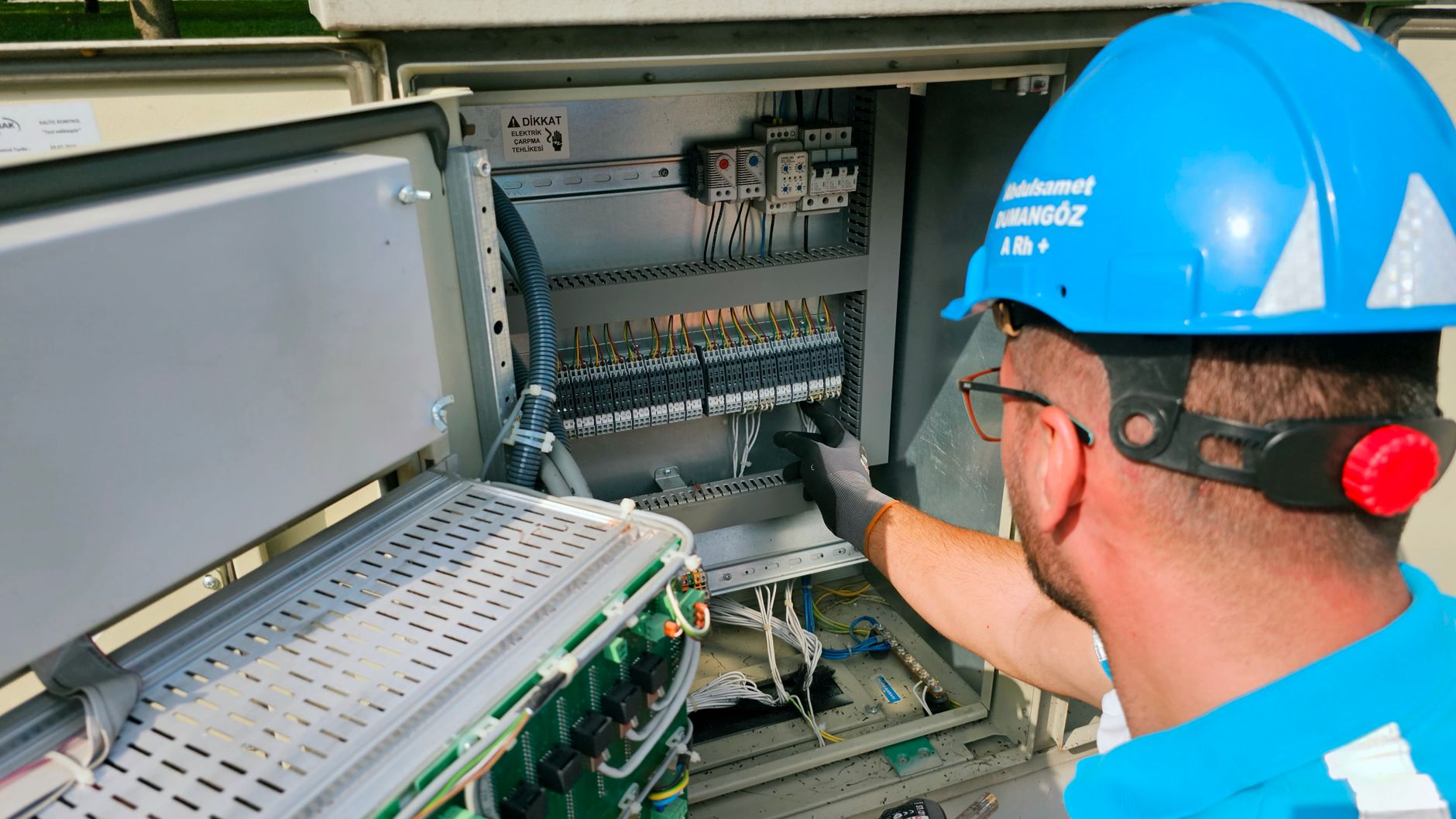 Worker inspecting an electrical control cabinet